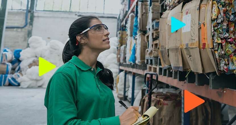 Mulher analisando estoque em galpão de reciclagem
