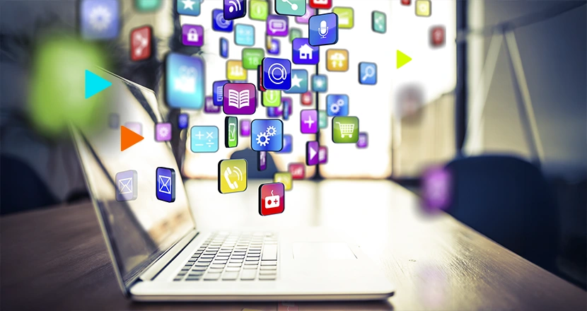 Notebook cercada por ícones tecnológicos para representar os novos apps da omie store